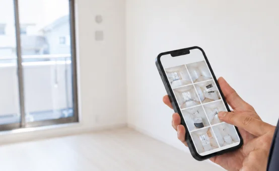 スマートフォンで完了後の部屋の写真を確認している様子